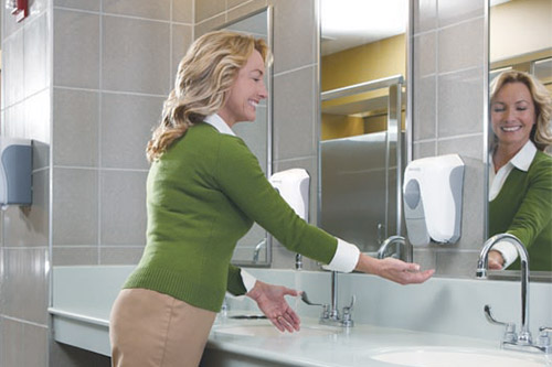 Happy customer washing hands in a clean bathroom