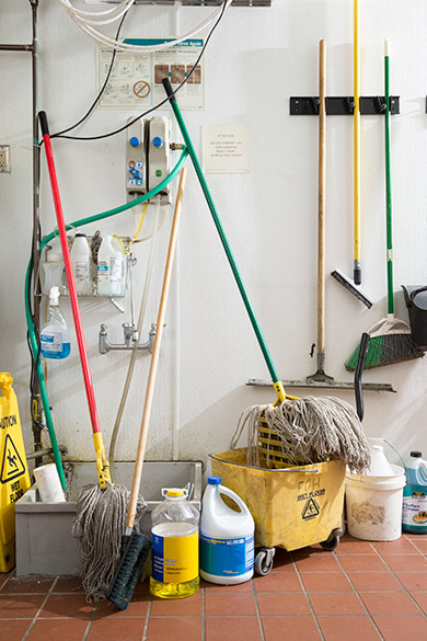 Dirty slop sink, mops, mop buckets, etc and empty chemicals before Cintas services