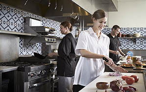 女副厨穿着白色厨师衬衫黑色厨师裤切洋葱